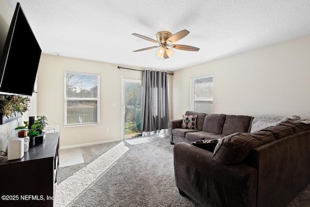 carpeted living room featuring plenty of natural light, a textured ceiling, and ceiling fan