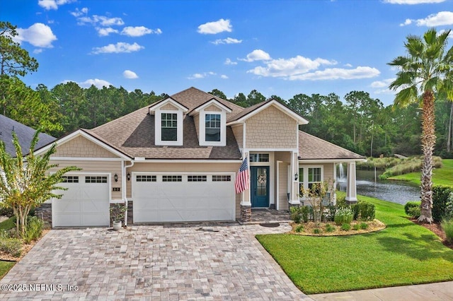 craftsman house with a water view and a front yard