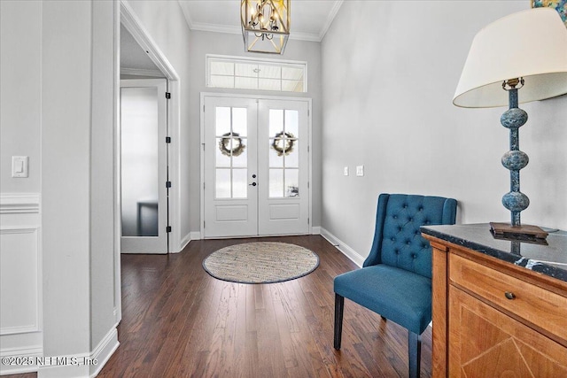 entryway featuring french doors, crown molding, dark wood-type flooring, and a notable chandelier