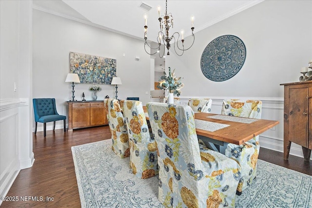 dining area with ornamental molding, dark wood-type flooring, and a notable chandelier