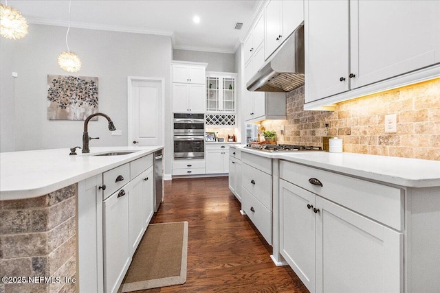 kitchen with sink, ornamental molding, appliances with stainless steel finishes, pendant lighting, and decorative backsplash