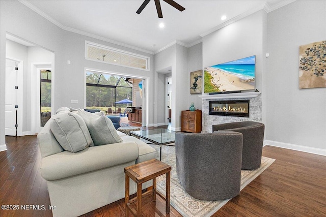 living room featuring dark hardwood / wood-style flooring, crown molding, ceiling fan, and a towering ceiling