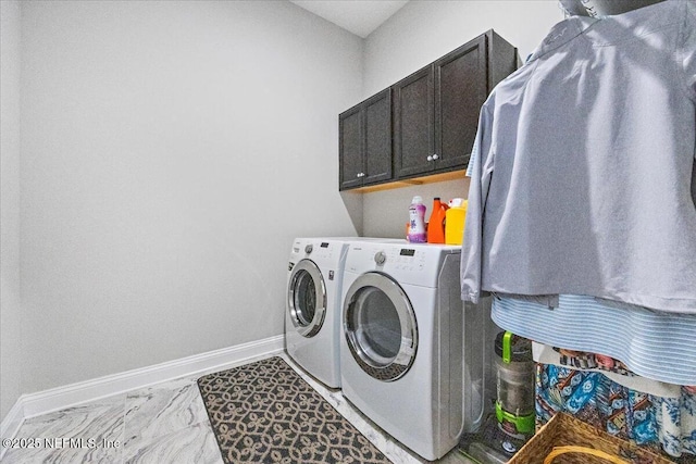 washroom featuring washing machine and dryer and cabinets