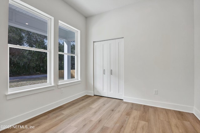 unfurnished bedroom featuring a closet and light hardwood / wood-style flooring