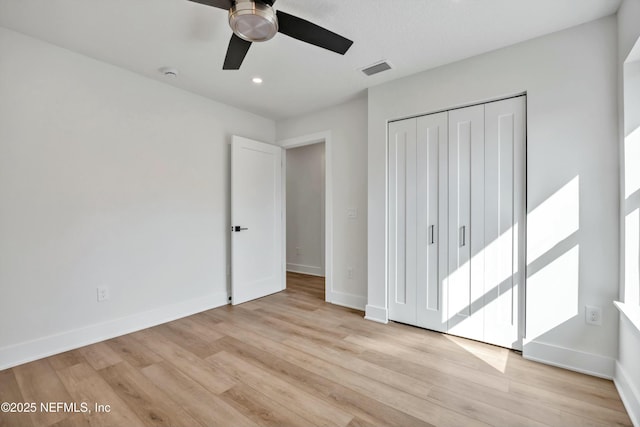 unfurnished bedroom featuring light hardwood / wood-style floors, a closet, and ceiling fan