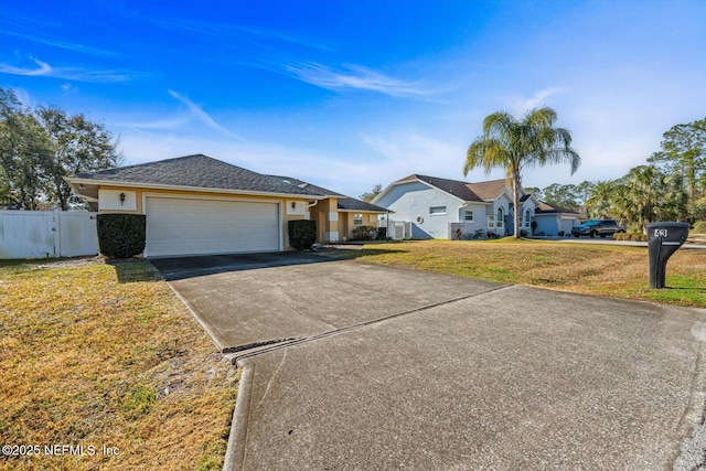 ranch-style house with cooling unit, a garage, and a front yard