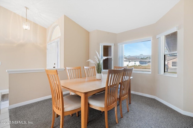 dining room with an inviting chandelier, vaulted ceiling, and carpet flooring