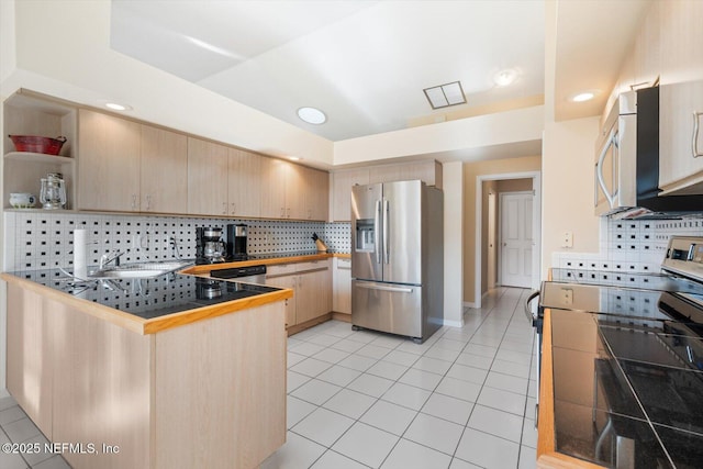 kitchen with appliances with stainless steel finishes, light brown cabinetry, sink, tile counters, and kitchen peninsula