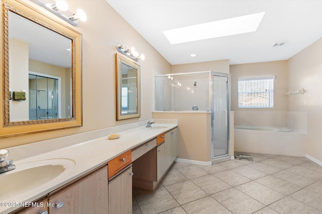 bathroom featuring plus walk in shower, vanity, tile patterned floors, and a skylight