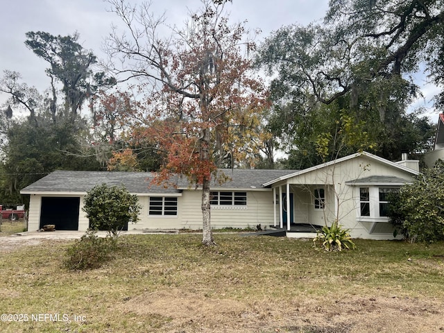 single story home featuring a garage, covered porch, and a front yard