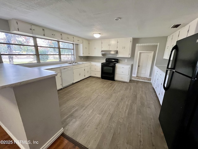 kitchen with white cabinetry, sink, light wood-type flooring, black appliances, and a textured ceiling