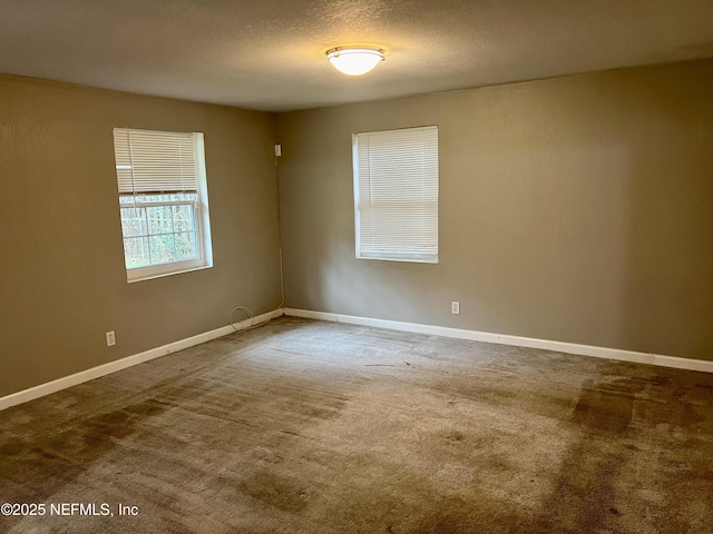 carpeted spare room with a textured ceiling