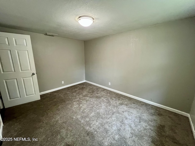 carpeted spare room featuring a textured ceiling