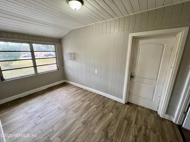 spare room featuring wood ceiling, vaulted ceiling, and light hardwood / wood-style flooring