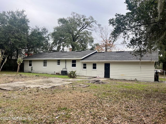 rear view of property with a yard, central AC unit, and a patio area