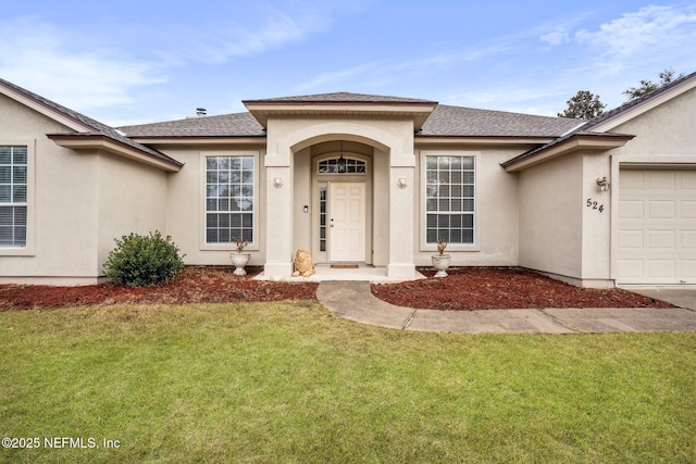 view of exterior entry with a garage and a lawn