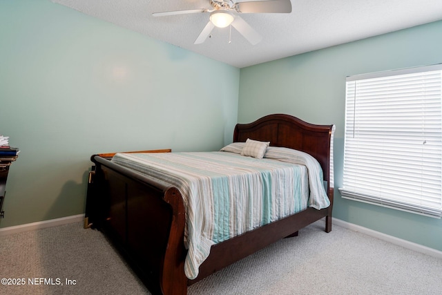 carpeted bedroom featuring a textured ceiling and ceiling fan