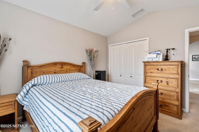 bedroom with vaulted ceiling, light carpet, ceiling fan, and a closet