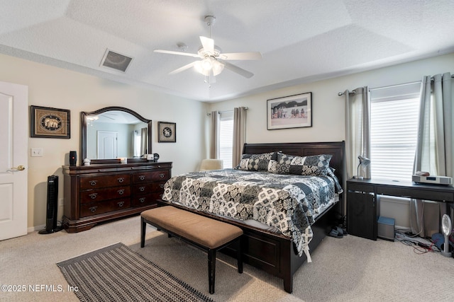 carpeted bedroom with ceiling fan and a textured ceiling