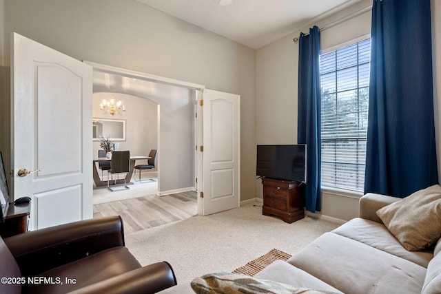 living room featuring light colored carpet and a notable chandelier