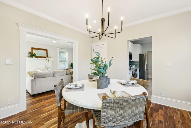 dining area featuring ornamental molding, dark wood-type flooring, and an inviting chandelier