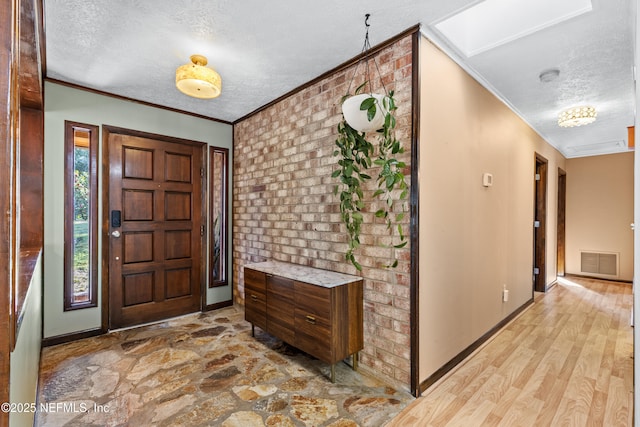 entryway featuring crown molding, a textured ceiling, and light wood-type flooring