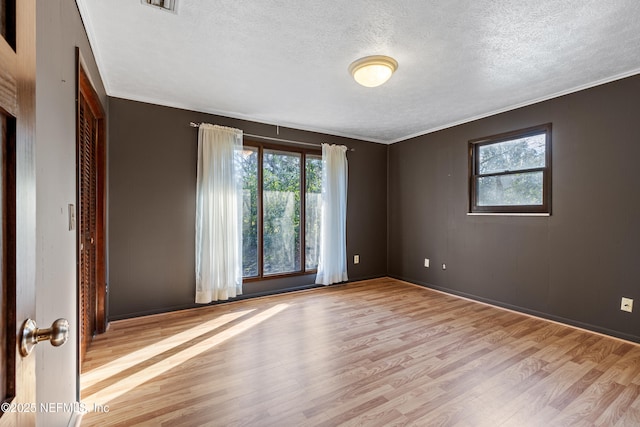 spare room with a healthy amount of sunlight and light hardwood / wood-style flooring