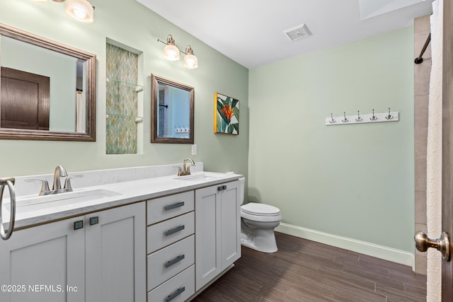 bathroom featuring vanity, wood-type flooring, and toilet