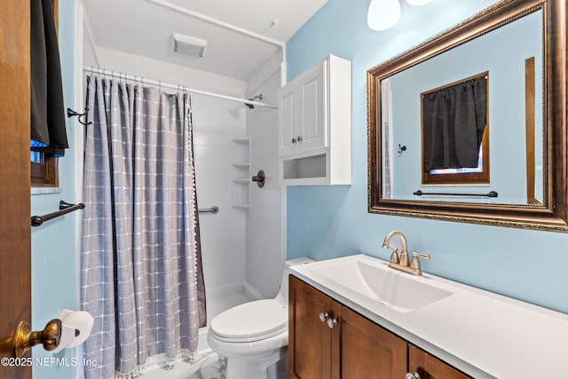 bathroom featuring toilet, vanity, and a shower with curtain