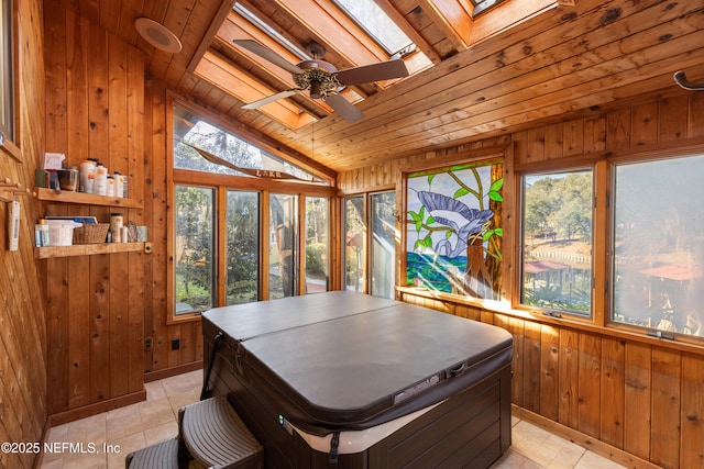 sunroom / solarium featuring ceiling fan, lofted ceiling with skylight, wooden ceiling, and a healthy amount of sunlight