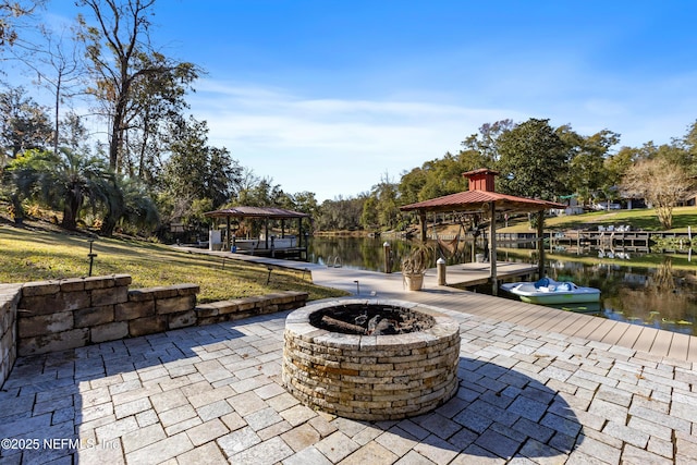 view of patio / terrace featuring a gazebo, a water view, a dock, and a fire pit