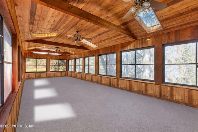 unfurnished sunroom with ceiling fan, vaulted ceiling with skylight, and wood ceiling