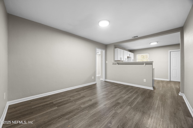 unfurnished living room featuring dark wood-type flooring