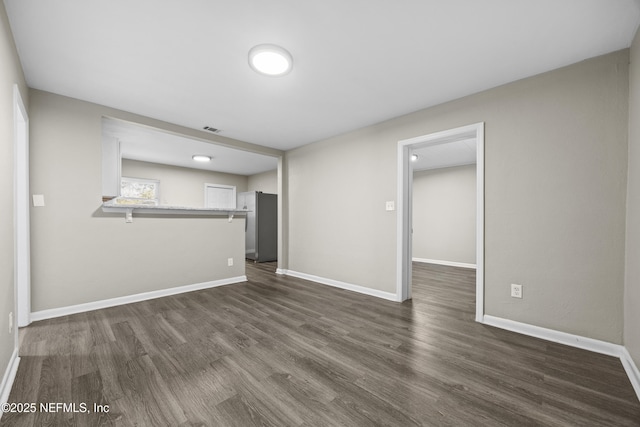 unfurnished living room with dark hardwood / wood-style flooring