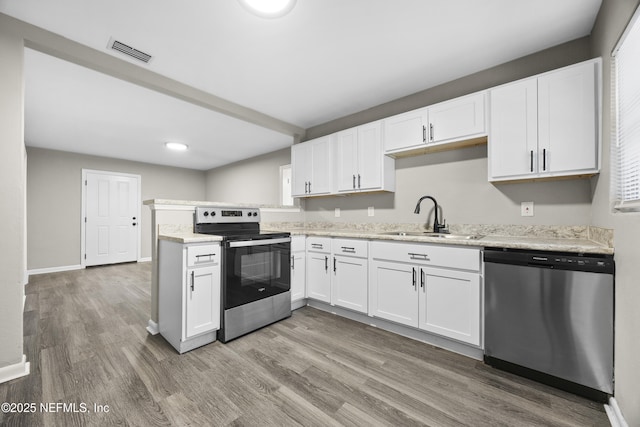 kitchen featuring sink, stainless steel appliances, light stone counters, wood-type flooring, and white cabinets