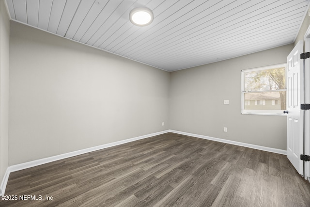 empty room with dark wood-type flooring and wood ceiling