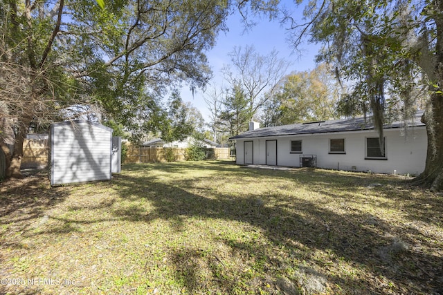 view of yard featuring cooling unit and a storage shed