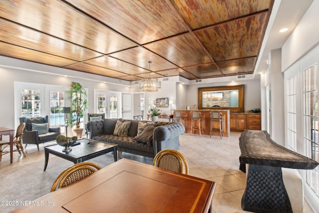 living room with an inviting chandelier, wooden ceiling, french doors, and light tile patterned flooring