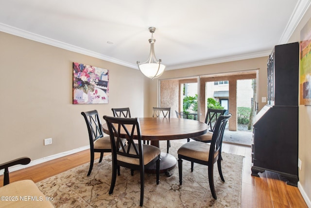 dining area with light hardwood / wood-style flooring and ornamental molding