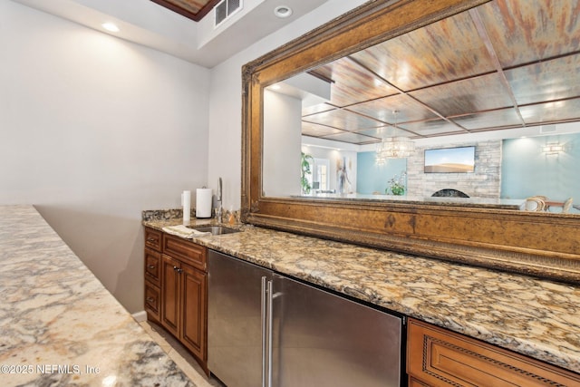 bar with light stone countertops and sink