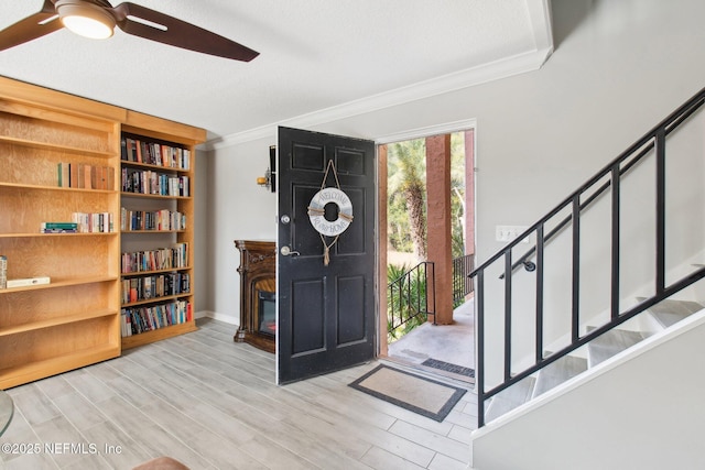 foyer featuring ceiling fan, ornamental molding, and light hardwood / wood-style floors