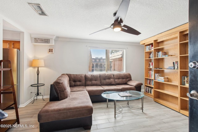 living room with ceiling fan, light hardwood / wood-style floors, and a textured ceiling