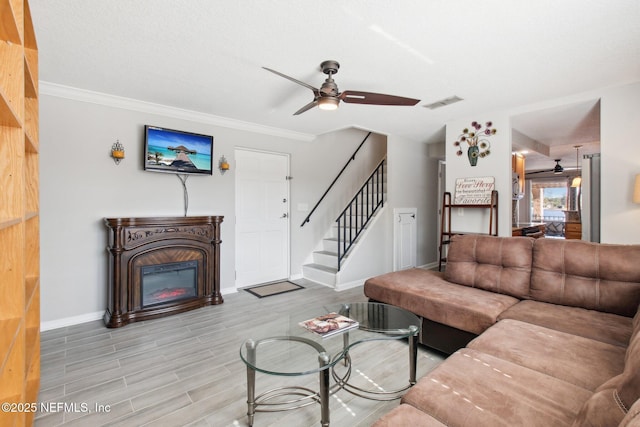 living room with crown molding, light hardwood / wood-style floors, and ceiling fan