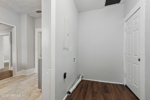 clothes washing area with washer hookup, hardwood / wood-style flooring, electric panel, and a textured ceiling