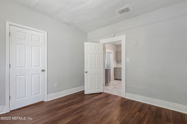 empty room featuring hardwood / wood-style floors and a textured ceiling