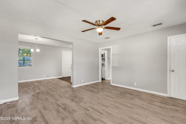 unfurnished room featuring ceiling fan with notable chandelier and light wood-type flooring