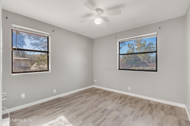 spare room with ceiling fan, plenty of natural light, and light hardwood / wood-style floors