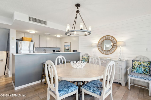 dining room featuring an inviting chandelier and light hardwood / wood-style floors