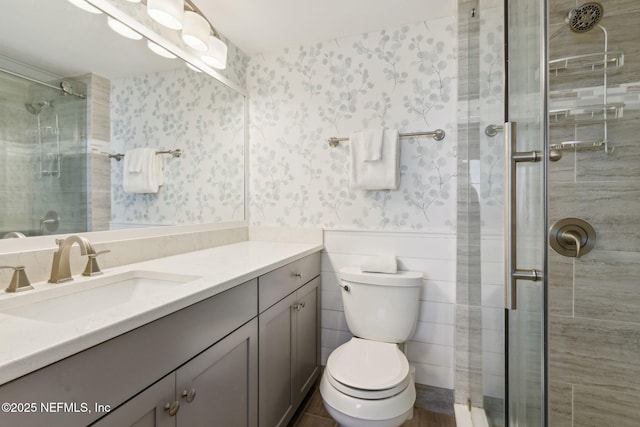 bathroom with vanity, a shower with door, and toilet