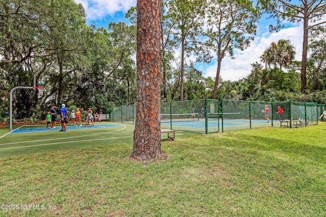 view of sport court featuring a playground, basketball court, and a lawn